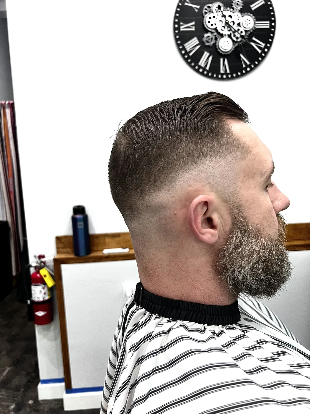 High skin fade with slicked-back top and beard trim at The Gilded Edge, West Seattle barbershop
